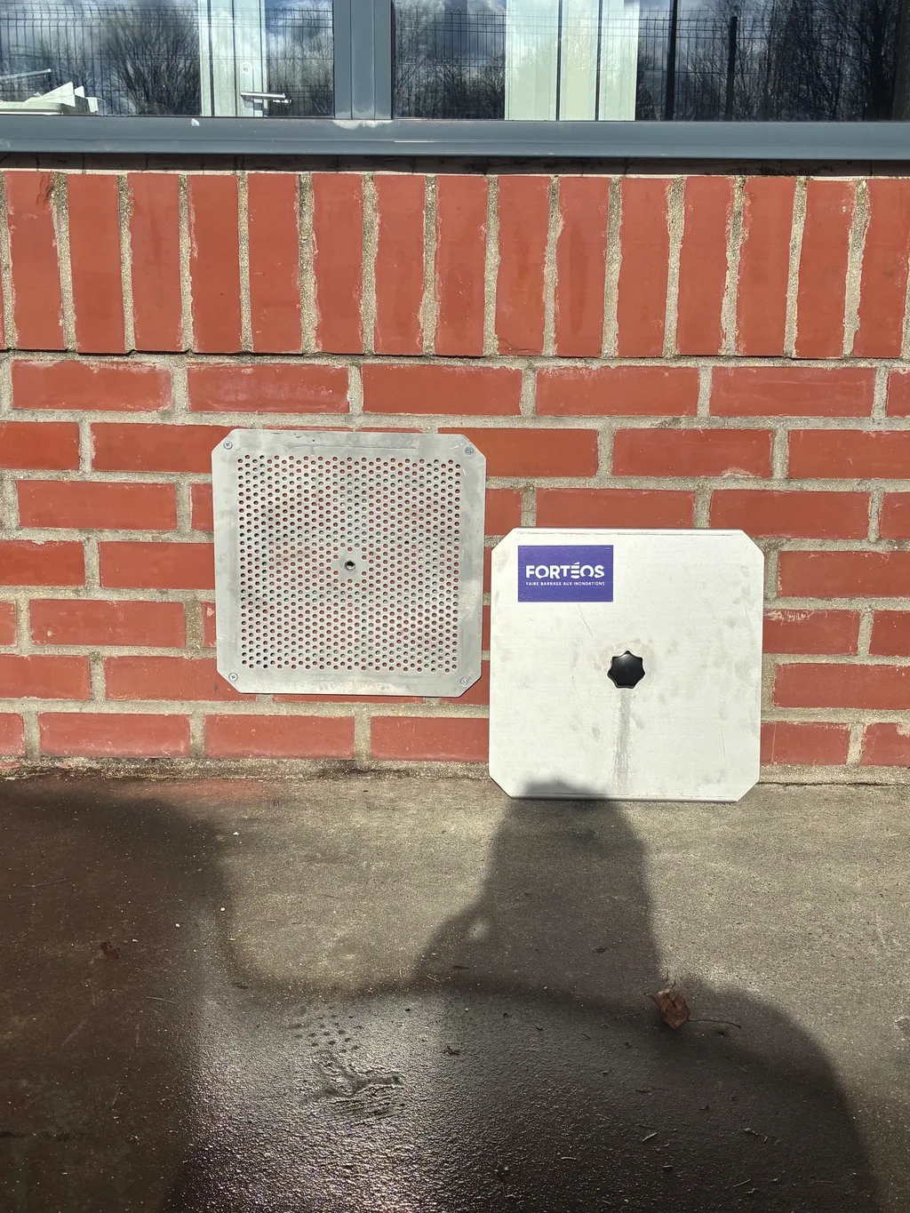 Obturation de point bas Fortéos posée sur un mur : grille perforée et plaque pleine